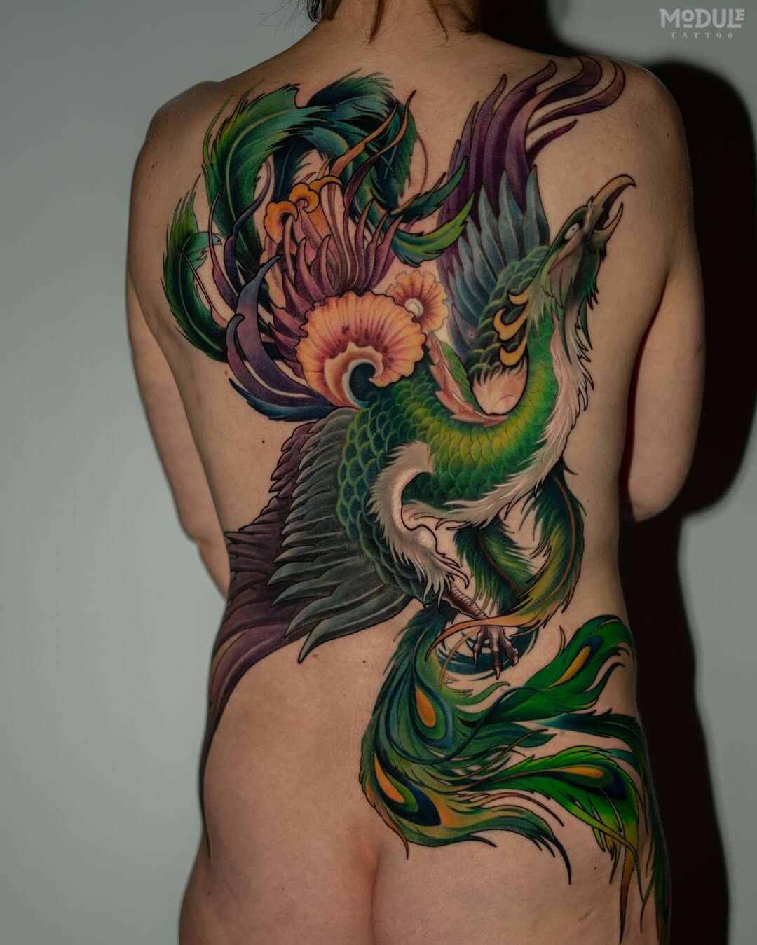 Artistic Neo-Oriental back tattoo showcasing fluid composition, vibrant green and purple gradients, and expert Japanese-inspired mythology ink, by Rinat Tattarin Mingazdinov, Los Angeles, West Hollywood