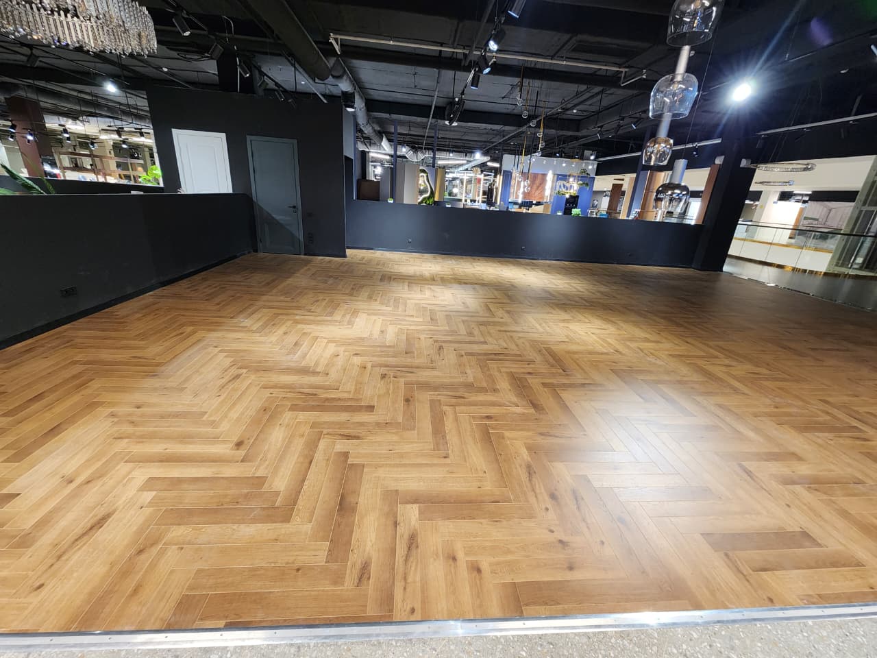 Укладка ламината Norland Herringbone Elegant в торговом центре «Кубатура». Элегантный рисунок пола подчёркивает свет и архитектуру пространства, создавая эффект дорогого паркета.