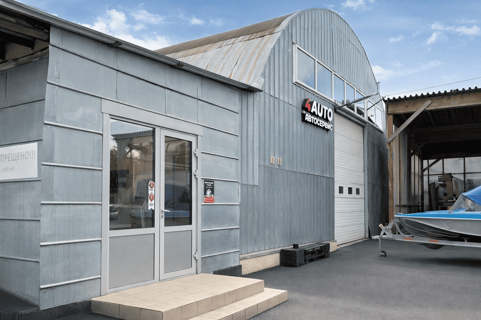 Автосервис 4AUTO с металлическим фасадом и воротами, аккуратный вход с остеклённой дверью и вывеской