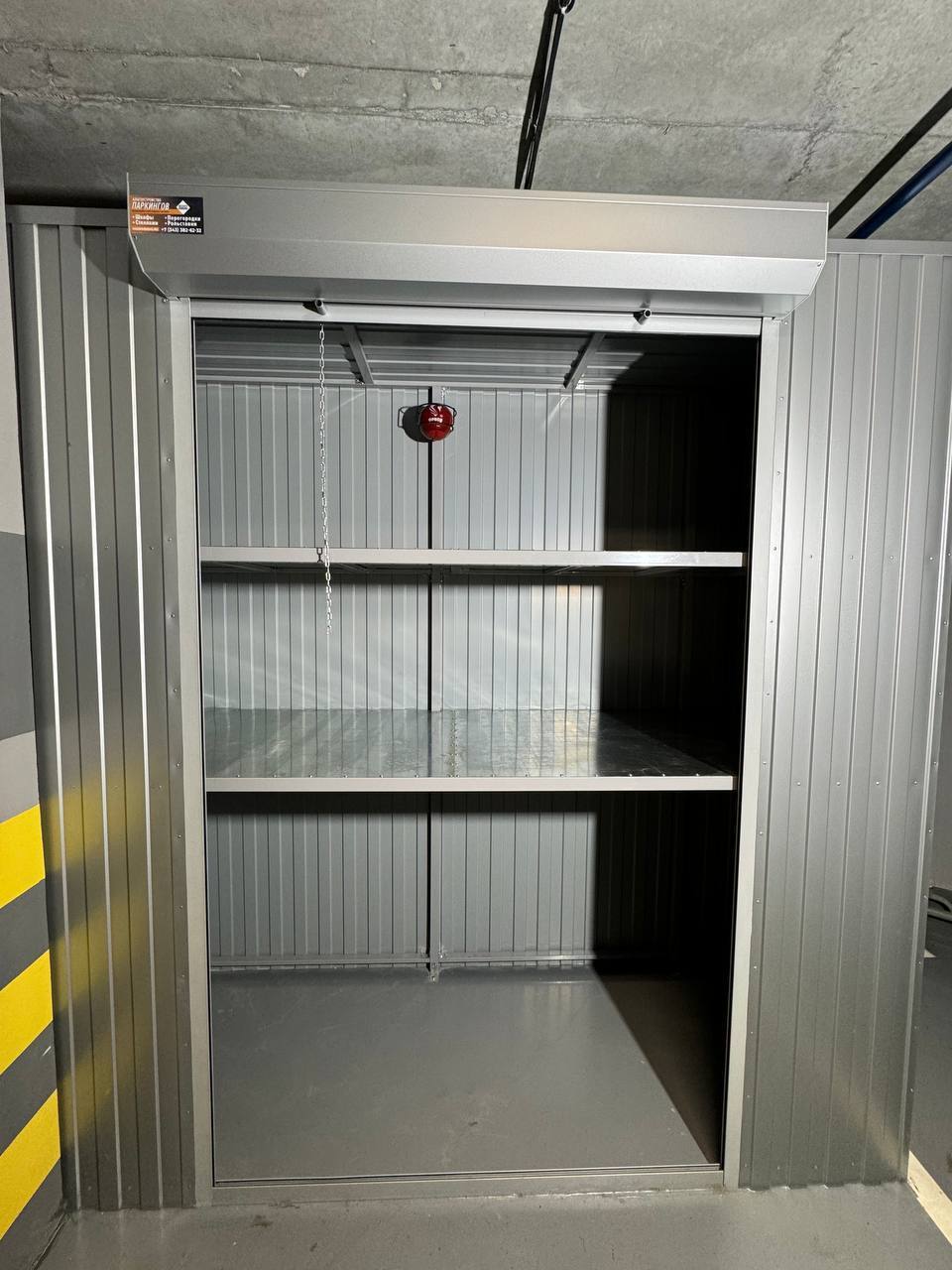 Роллетный шкаф-кладовая в паркинг (MaxParking) серебристого цвета из профлиста с металлическими полками для хранения шин, покрышек, сноубордов и лыж