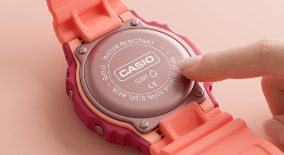 Палец проверяет лазерную гравировку задней крышки часов Casio