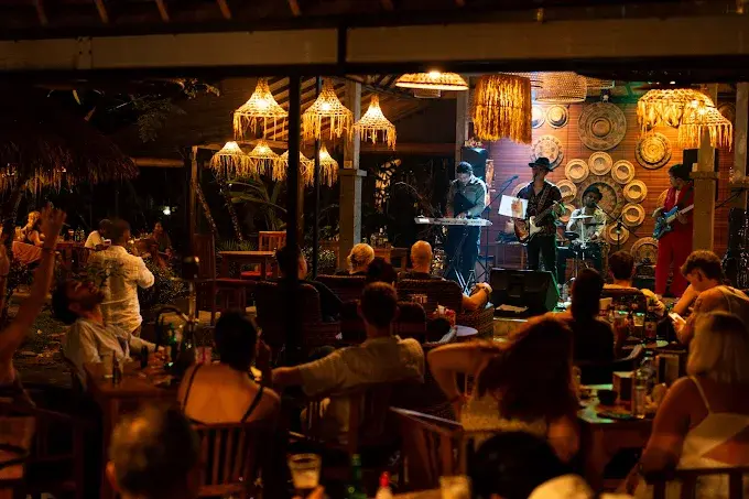 A live band performing for a relaxed, open-air crowd under warm woven lamps at Lokal Bar Ubud, a cozy community favorite among the best bars in Bali.