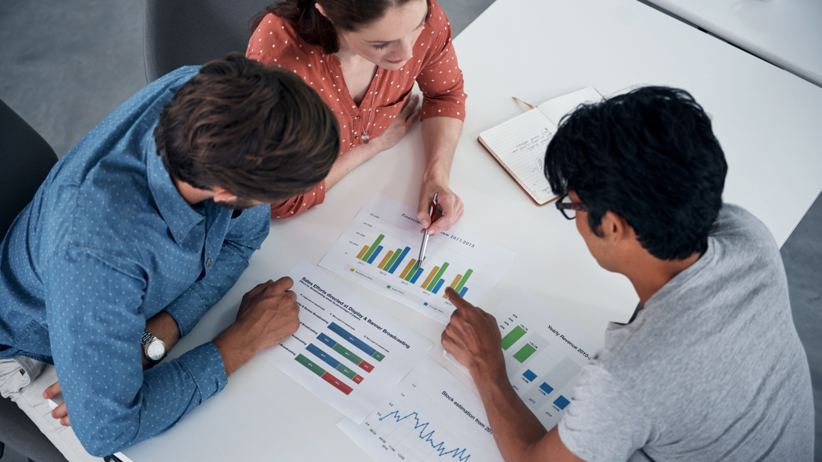 A group of three people working on revenue forecasting models.