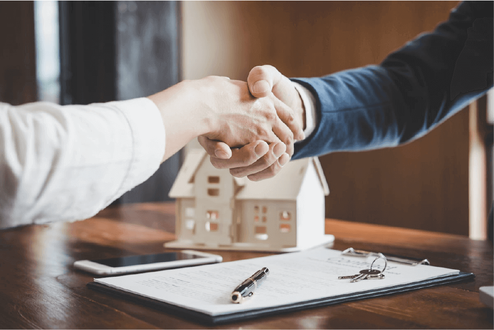 It is evident that people are shaking hands during the signing of a real estate sale.