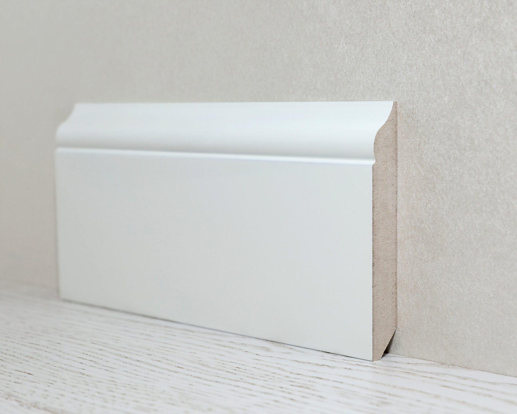 На фоне белой стены тонкий плинтус из МДФ будет практически незаметен.