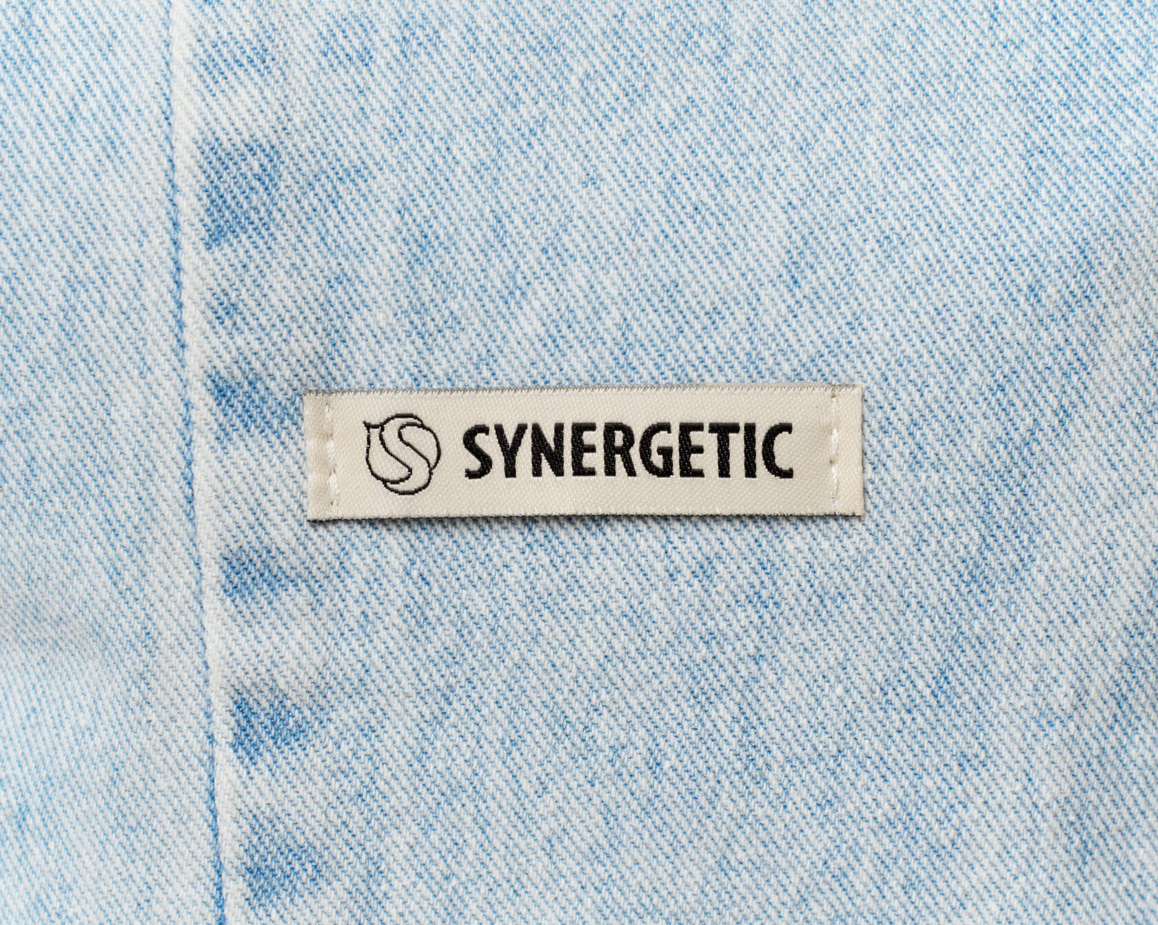 Тканевая шильда Synergetic на светлой джинсе, деталь