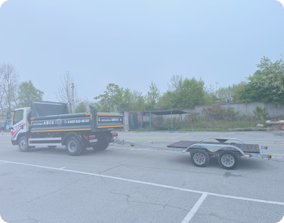 Черно-бронзовый мотоцикл стоит на стоянке у серого бетонного здания, вид сбоку