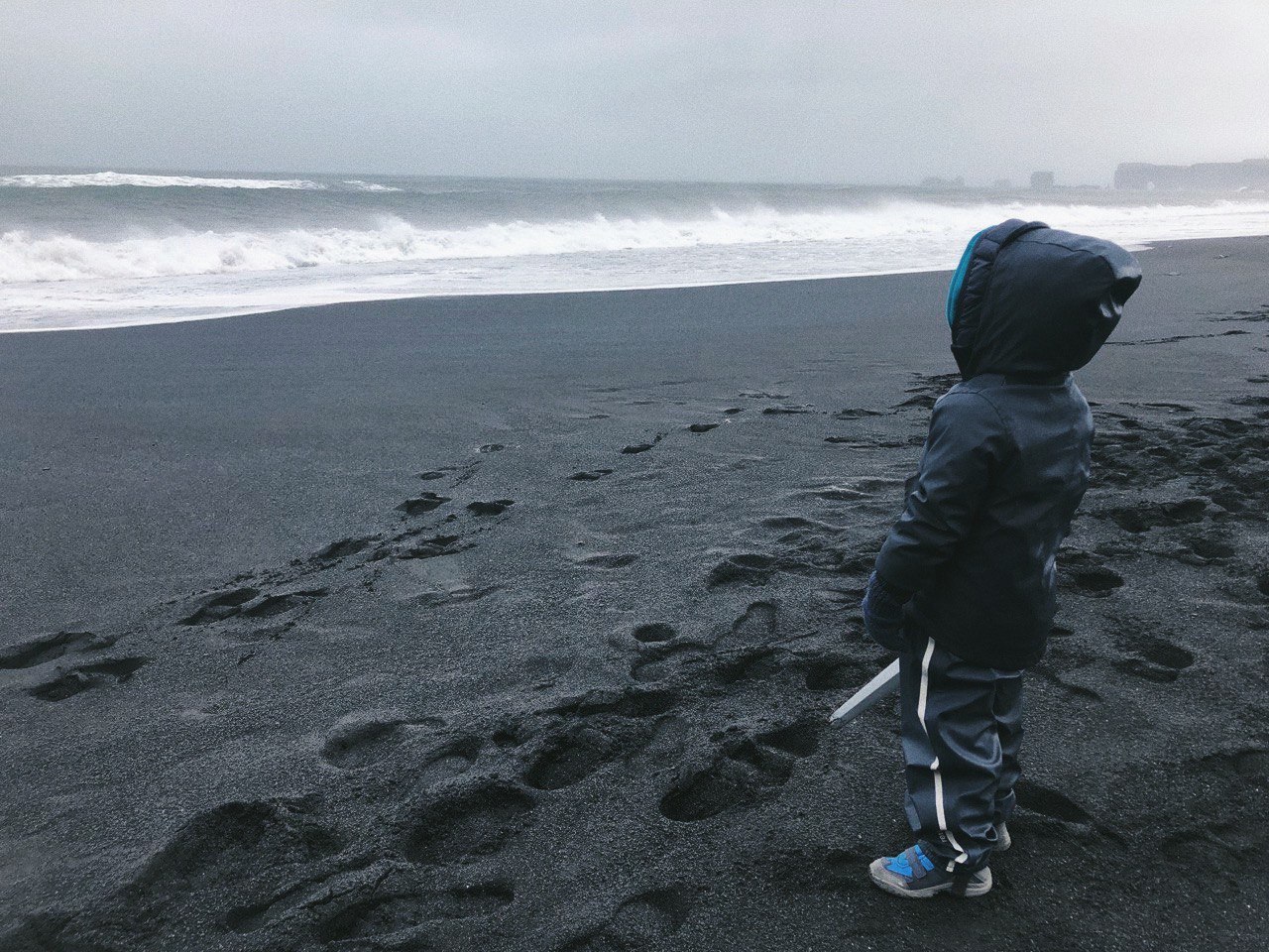 мальчик на берегу моря в Исландии