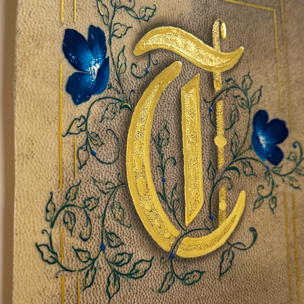 Gilded letter "T" on calfskin vellum. Pergament