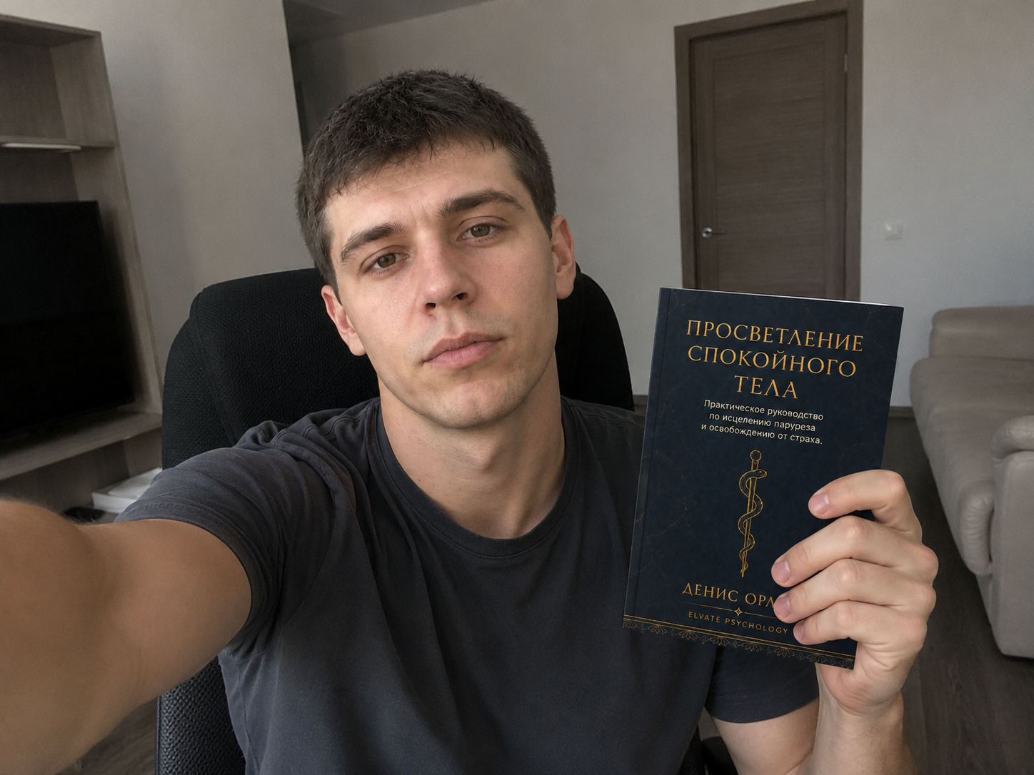 Денис Орлов держит книгу «Просветление спокойного тела»