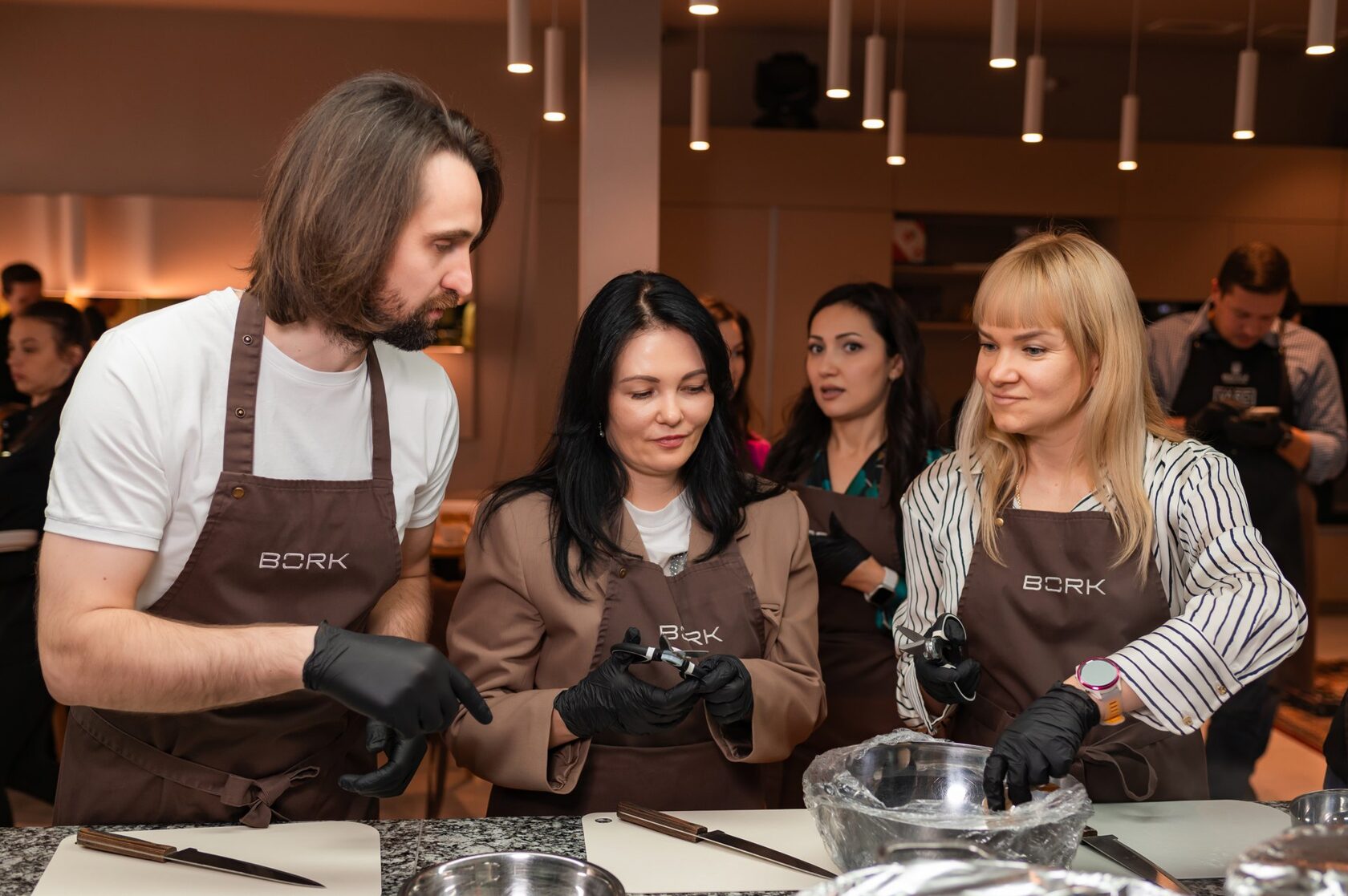 Шеф помогает гостям на кулинарном корпоративе