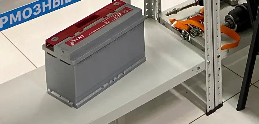 Автомобильный аккумулятор на стеллаже магазина БАМ-АВТО