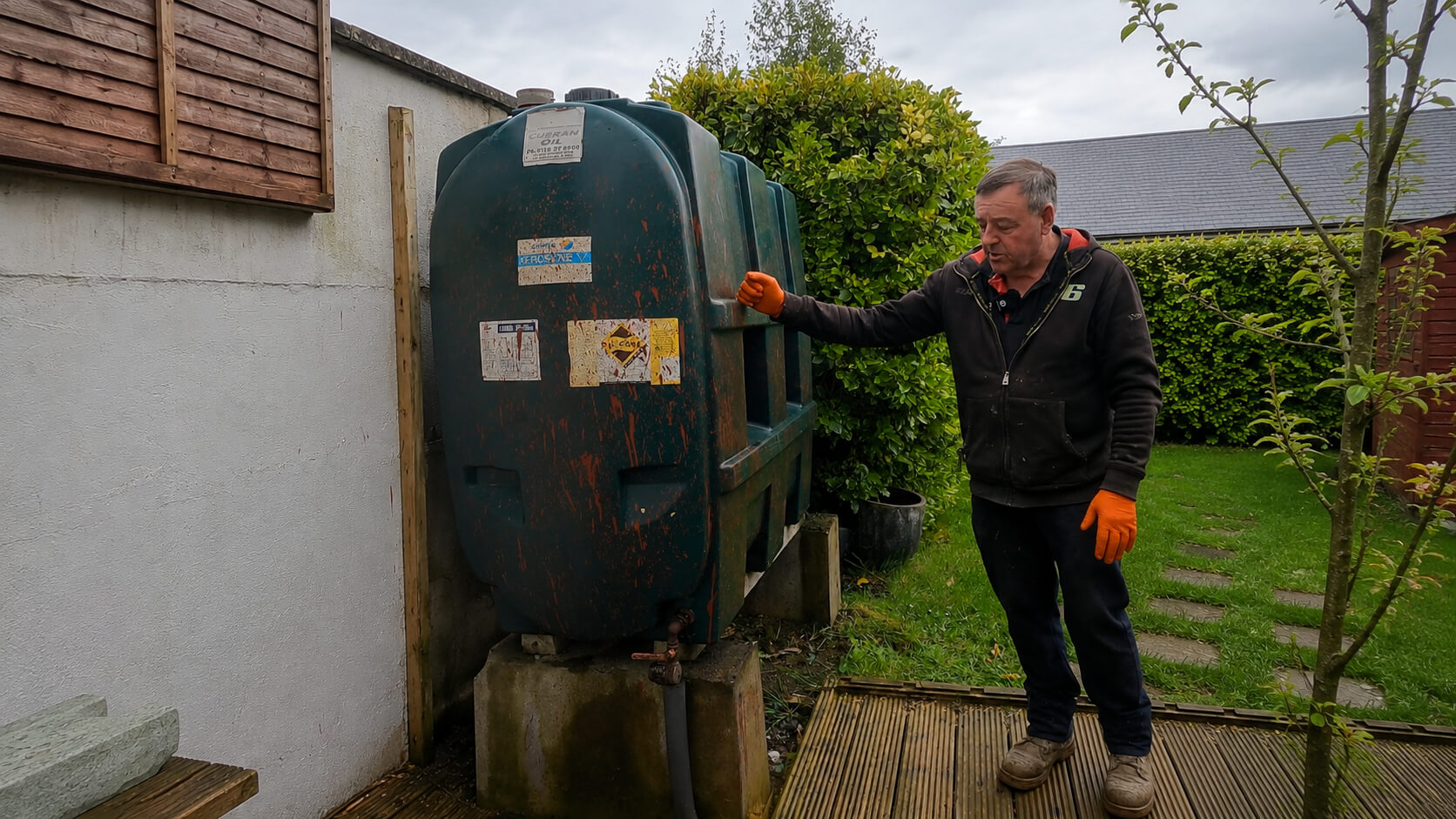 Old oil tank before replacement in Slane, Co. Meath, inspected beside a domestic garden wall