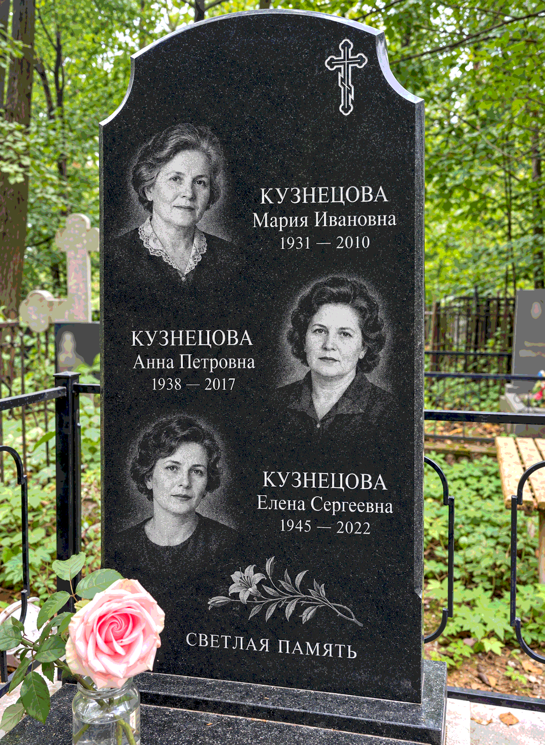 Деталь семейной фигурной стелы после установки на участке. Имена, даты и портреты изменены.