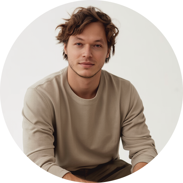Минималистичный портрет дизайнера Александра Музалевского в бежевом свитшоте на светлом фоне