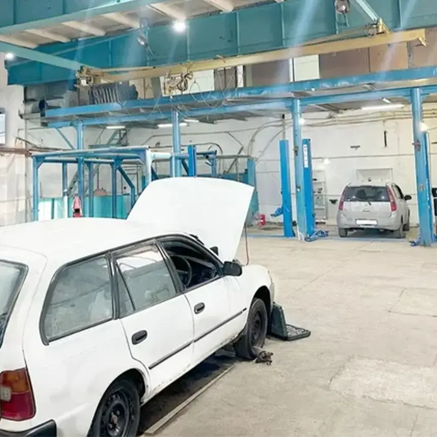 Ремзона автосервиса БАМ-АВТО в Иркутске: машина с открытым капотом и синие подъёмники