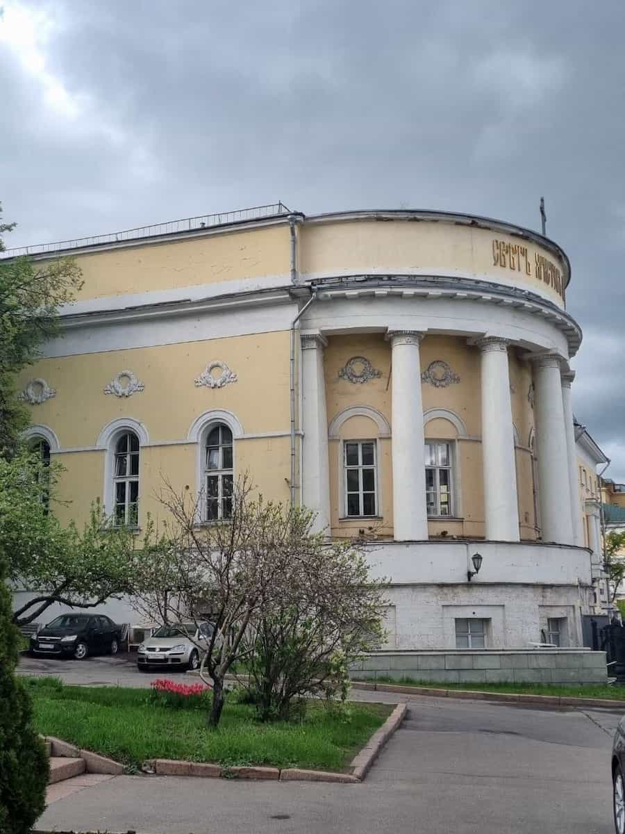 Желтое здание с полукруглым портиком и колоннами