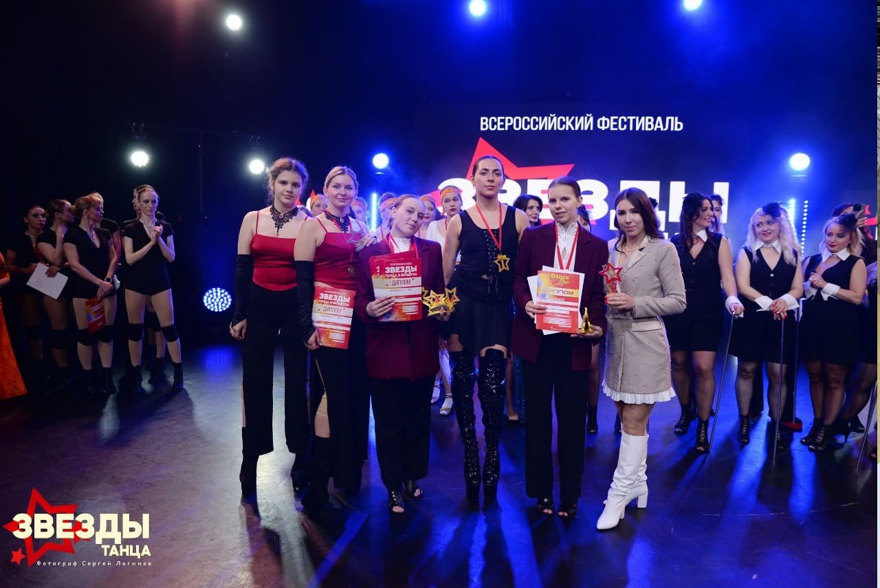 Команда танцевальной студии с наградами на сцене фестиваля