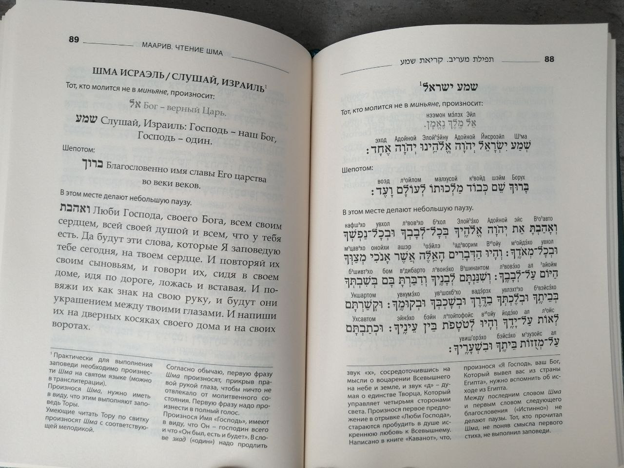 На странице сидура виден полный набор: священный текст на иврите, транслитерация для удобства чтения, русский перевод и комментарии. Такой формат делает книгу доступной как начинающим, так и опытным молящимся.