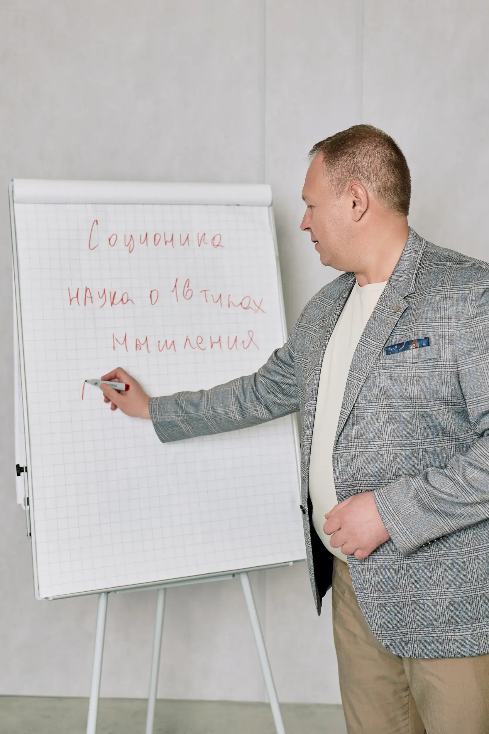 Андрей Стогов у флипчарта с надписью «Соционика — наука о 16 типах мышления»