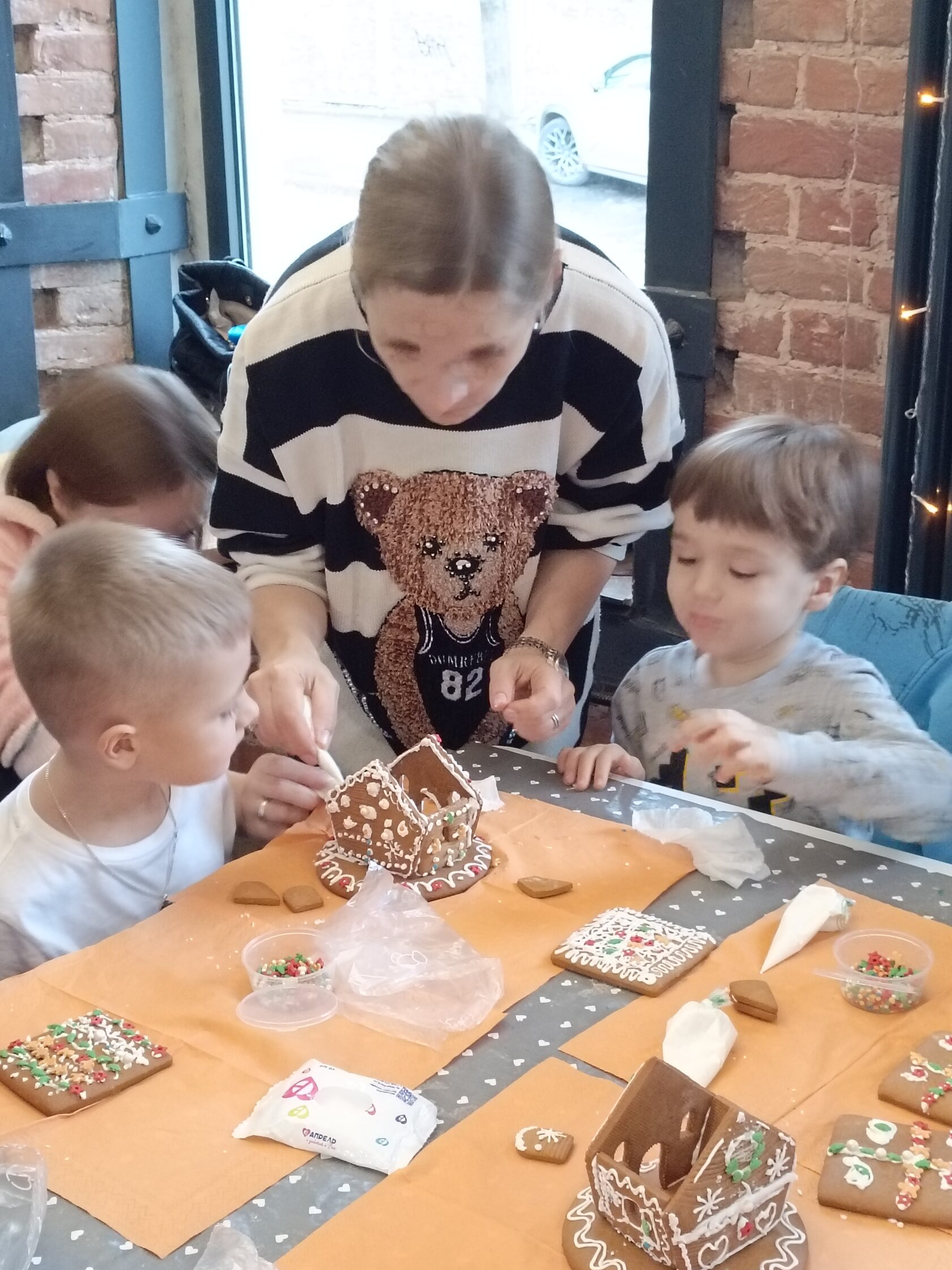 Семья за сборкой пряничного домика