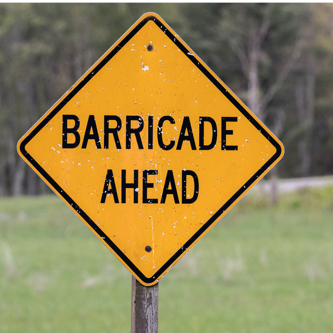 a barricade ahead sign in the middle of a field