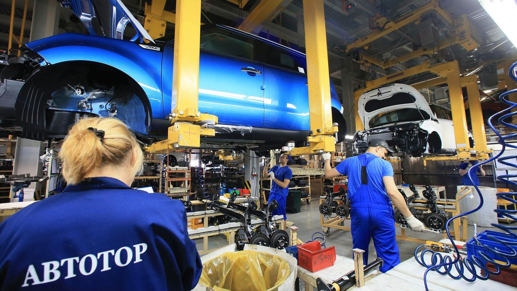 Рабочие завода Автотор на конвейере собирают автомобиль