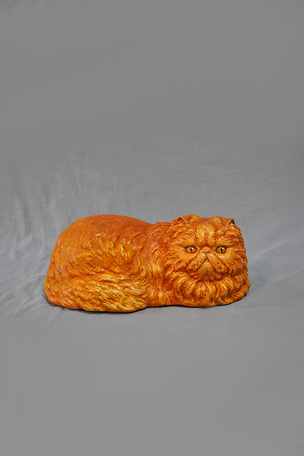 скульптура лежащего рыжего кота