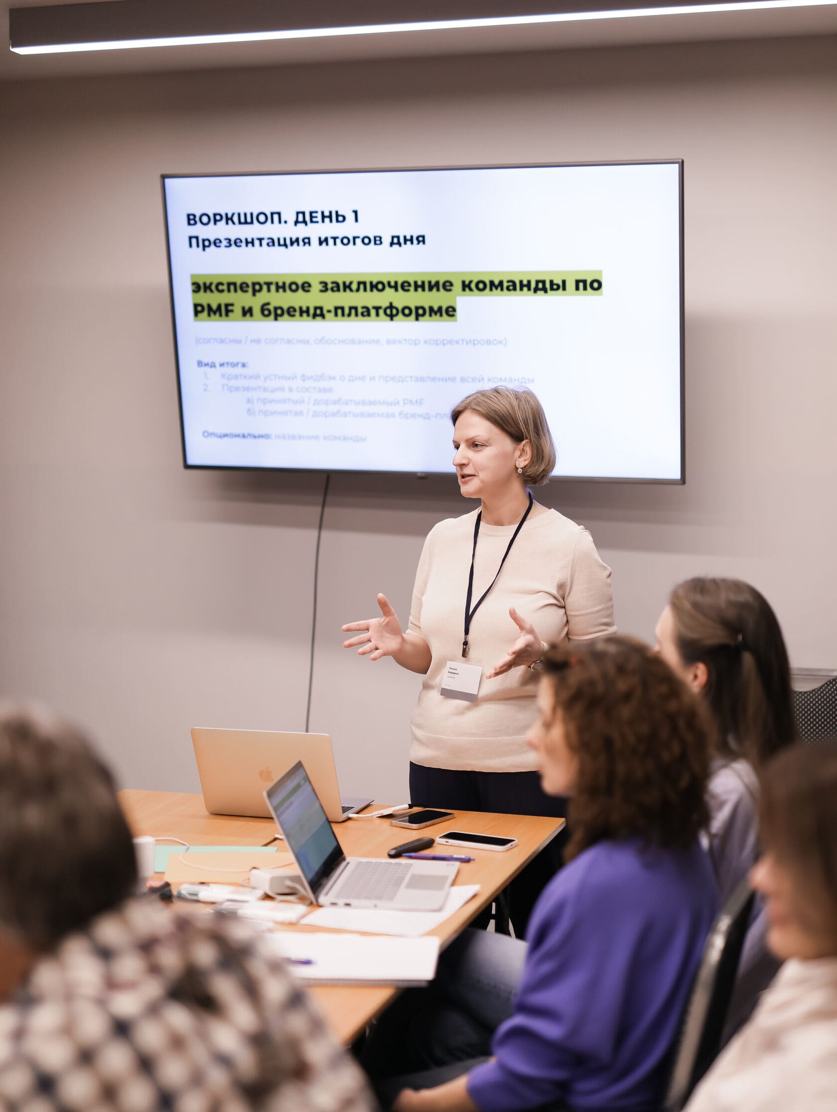 Татьяна Бородина проводит воркшоп презентация итогов дня перед командой у экрана