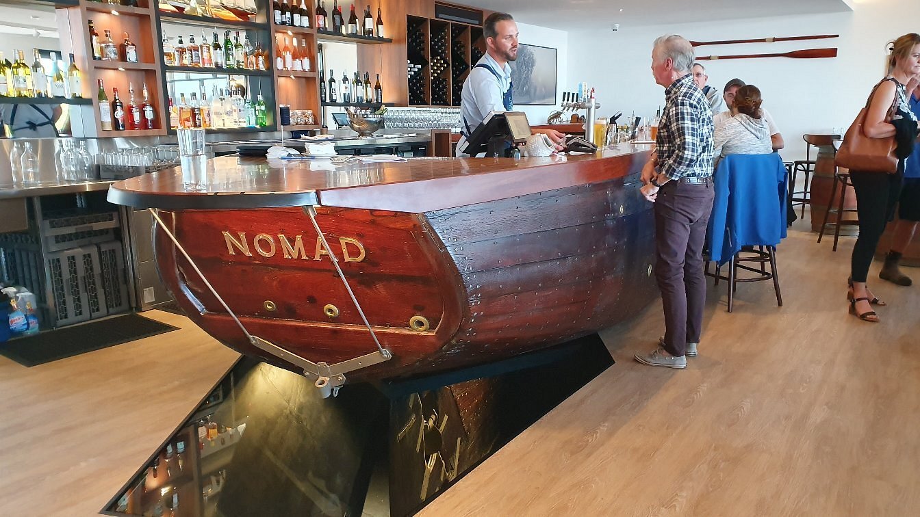 The Colour Patch Augusta – unique boat-shaped bar named Nomad, serving cocktails, wine, and local beer in a stylish riverside restaurant with relaxed, upscale atmosphere.