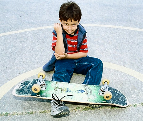 мальчик учится кататься на скейте
