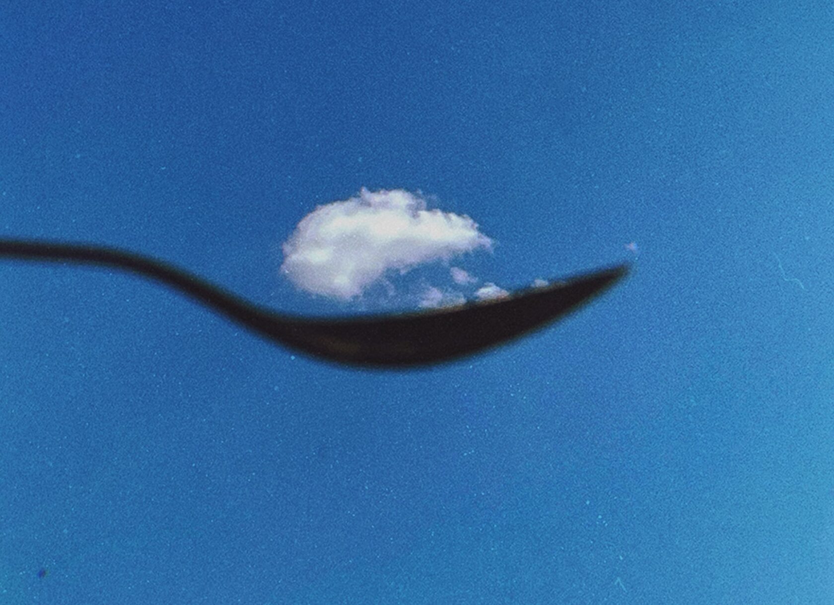 Визуальный эффект: черная ложна на фоне синего неба держит облако