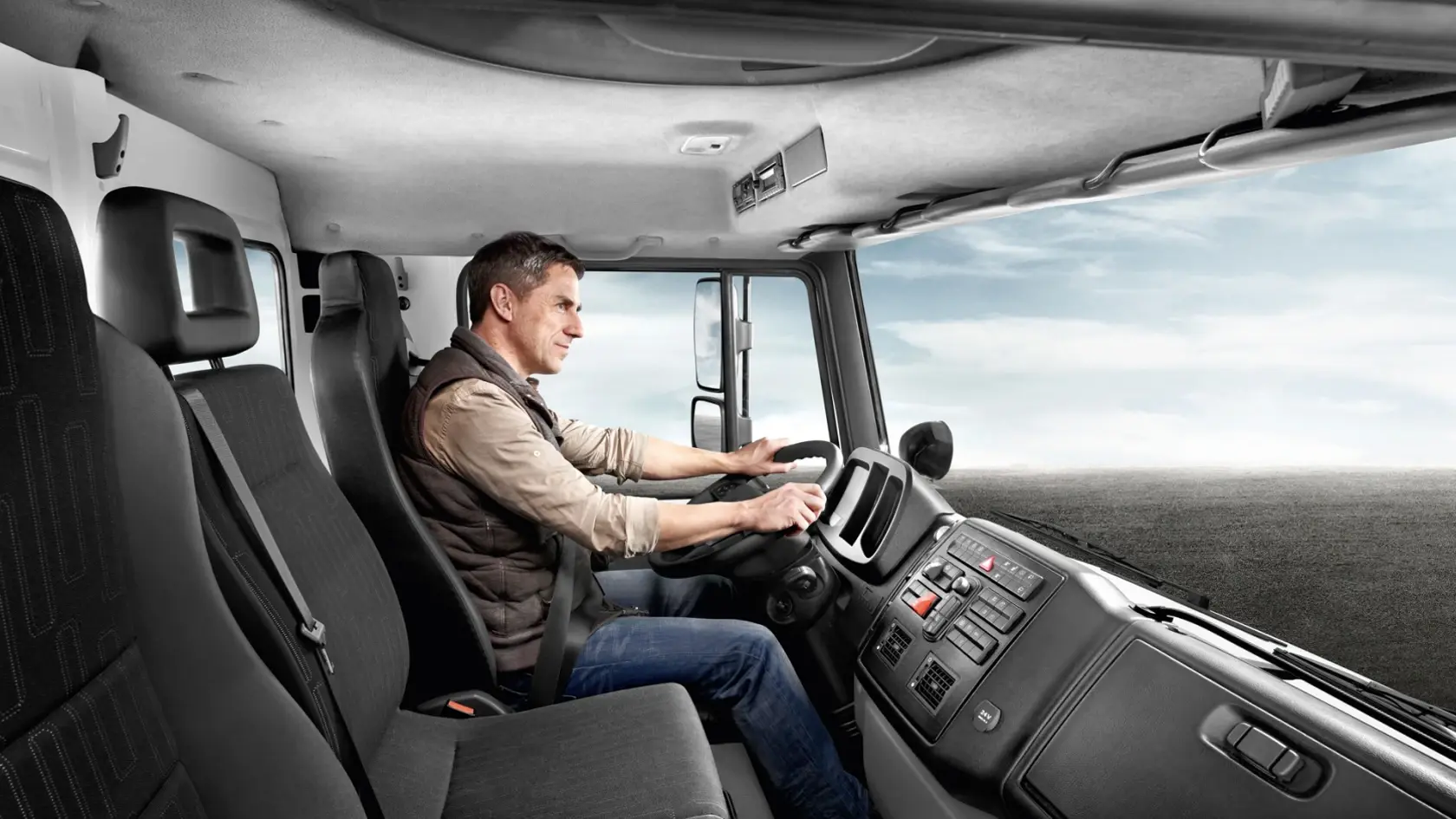 Вид в кабину Unimog: водитель за рулём управляет автомобилем