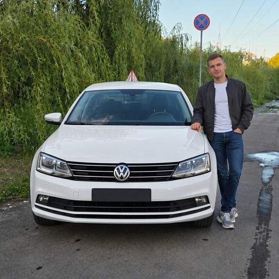 Выпускник автошколы у учебного автомобиля