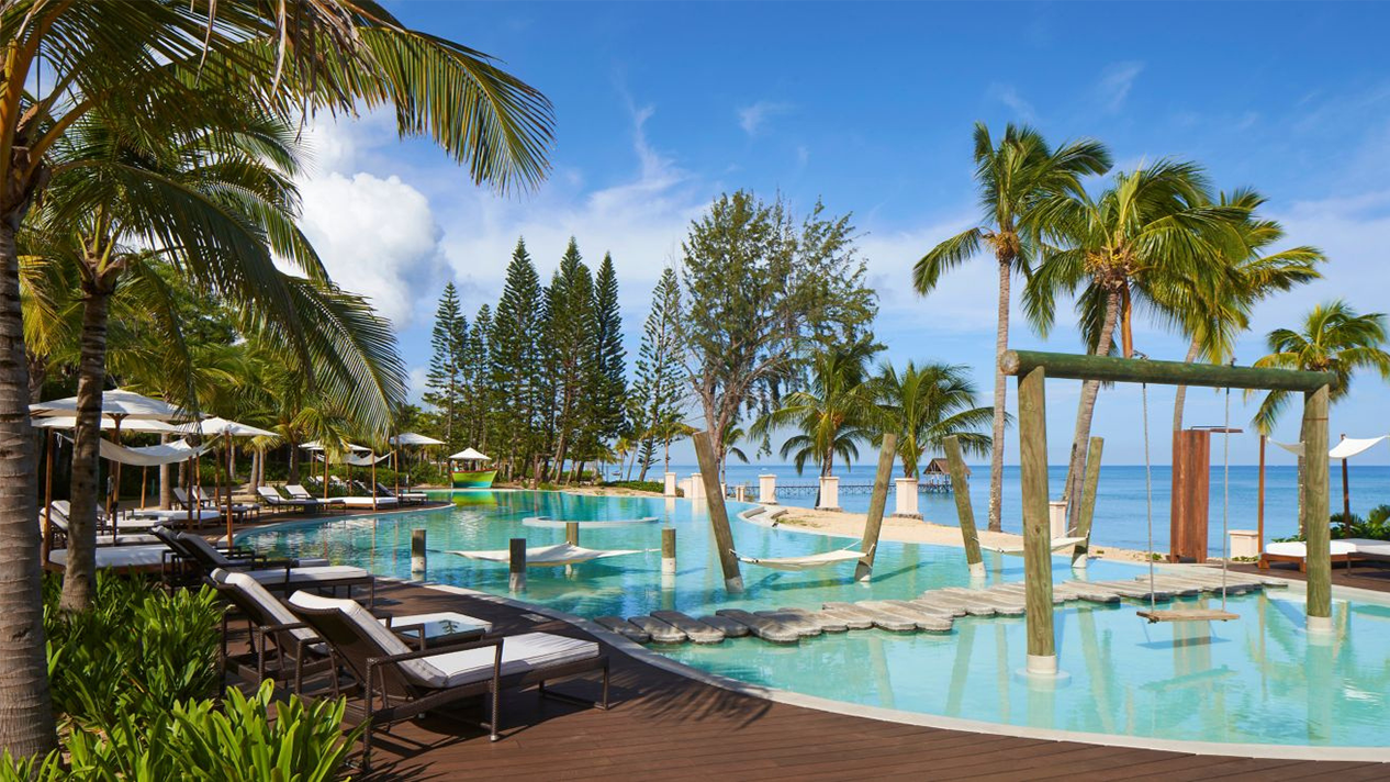 Семейный отдых на Маврикии в отеле Le Meridien Ile Maurice: бассейн, пляж и зона отдыха с качелями.