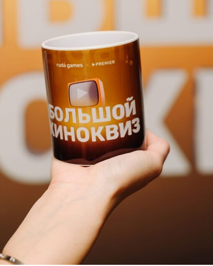 Стакан с оформлением «Большой киноквиз» в руке участника