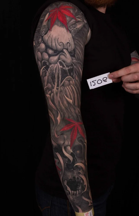 Full sleeve black and grey tattoo featuring a Japanese deity, a skull, and vibrant red maple (momiji) leaves, by Rinat Tattarin Mingazdinov. Los Angeles, West Hollywood