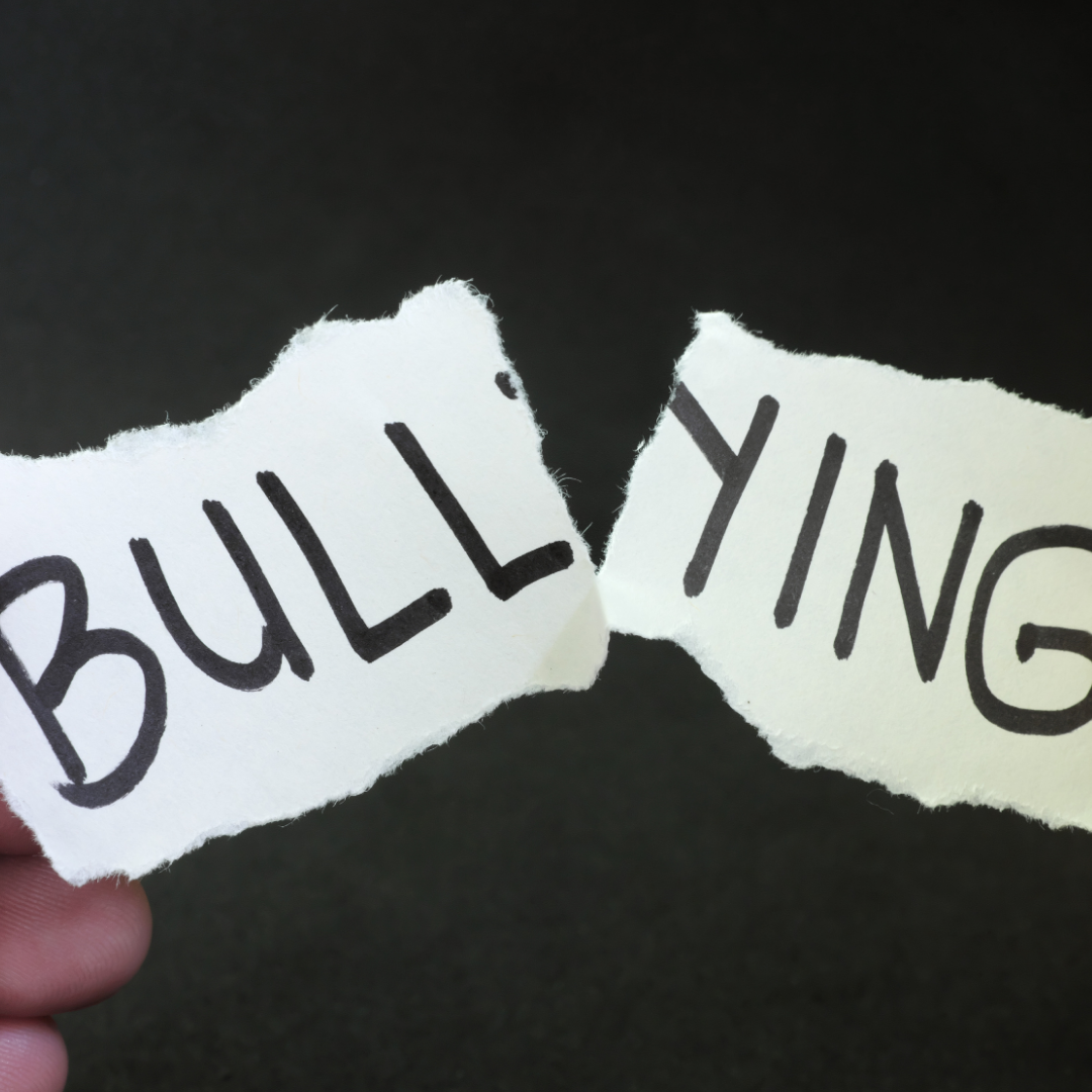 Words bullying written on paper that is ripped in half