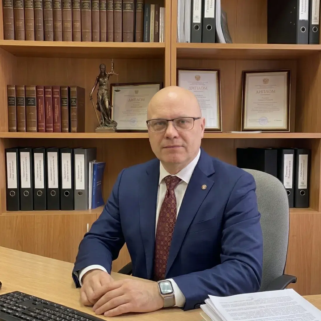Адвокат Павел Рябов у себя в кабинете за столом с документами