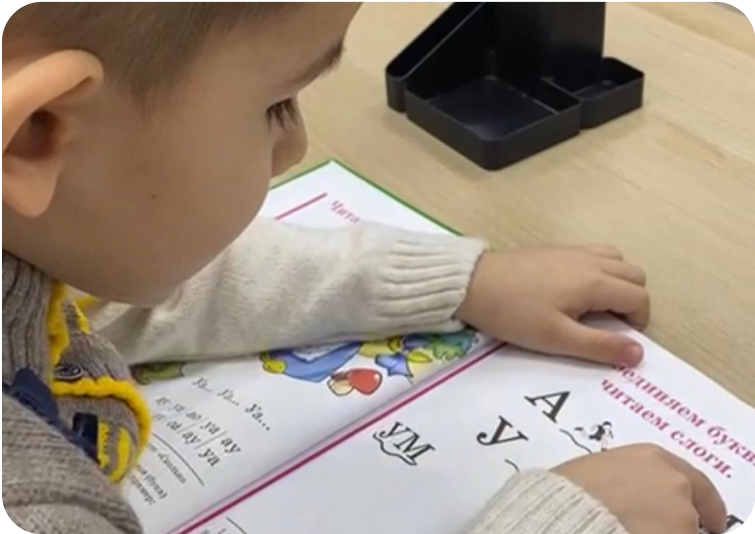 Ребенок читает букварь