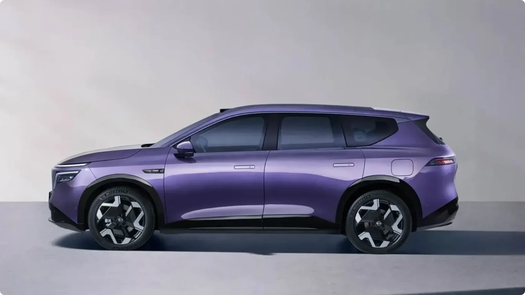 Боковой профиль нового электрического кроссовера Nissan NX8 в фиолетовом цвете в студии: длинная колесная база, утопленные дверные ручки и аэродинамические диски с шинами Michelin