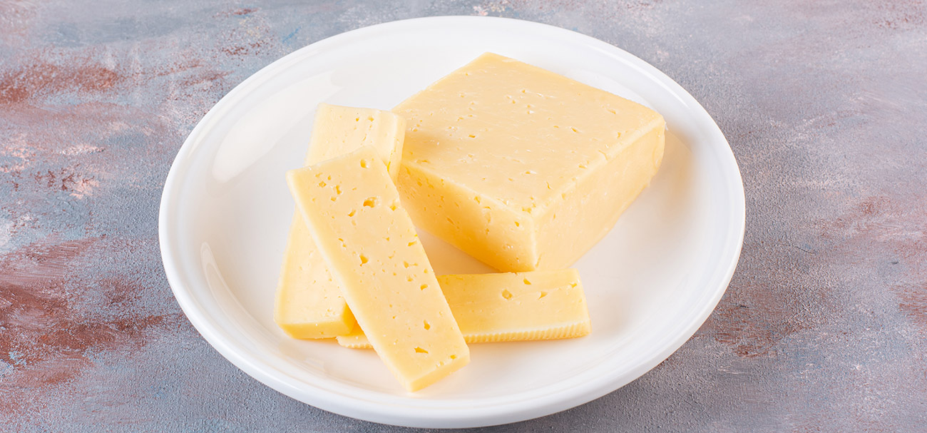 светло желтый полутвердый сыр. твёрдые сыры сорта. некачественный сыр. сыр твердых сортов. сыр чиз.