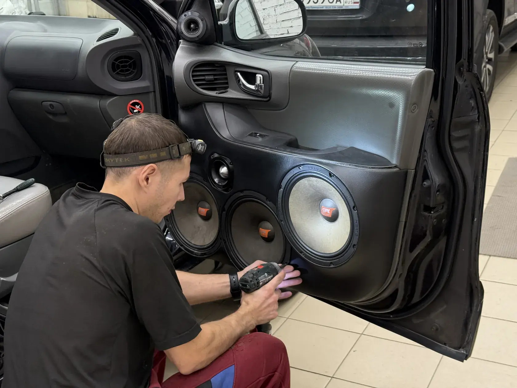 Мастер Legend Auto устанавливает акустическую карту на дверь