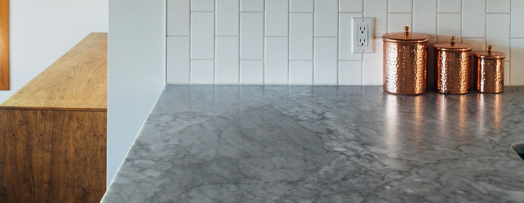 Close-up of a kitchen featuring a smooth gray quartz countertop with a sleek, polished surface, adding a modern and sophisticated touch to the space.