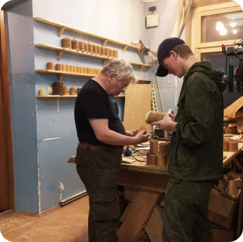 Мастер обучающий ученика в столярном деле.