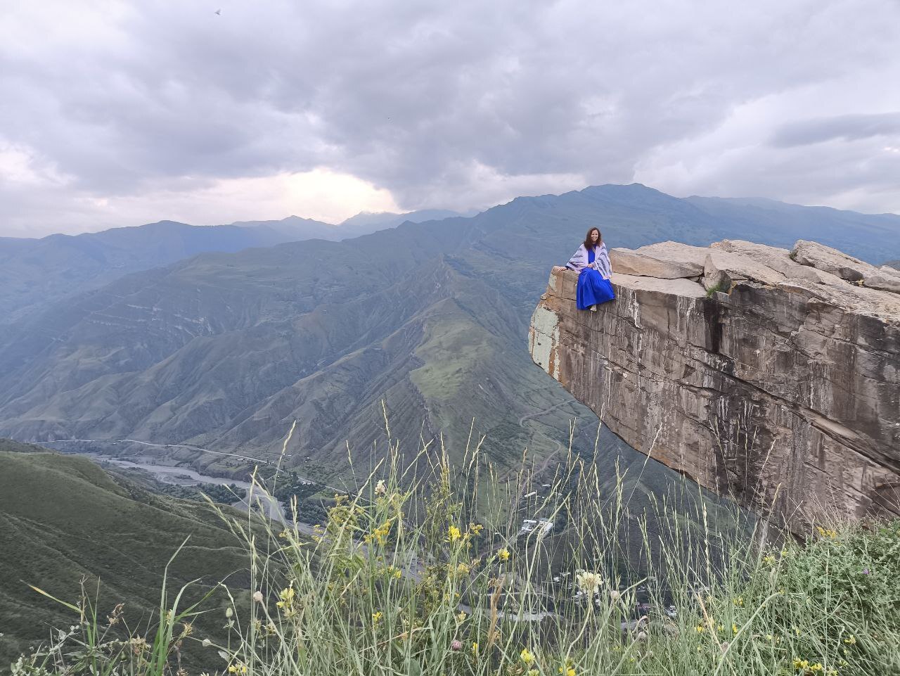 Гид рассказывает группе туристов историю у сторожевой башни в древнем ауле Гоор.