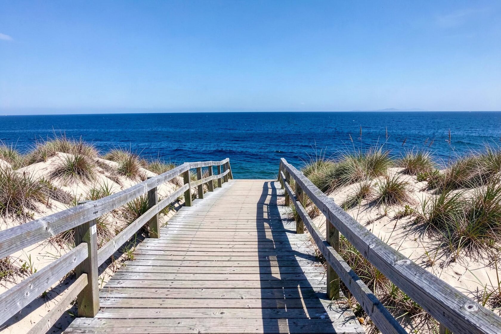 Pasarela de madera a través de las dunas que conduce al mar Mediterráneo