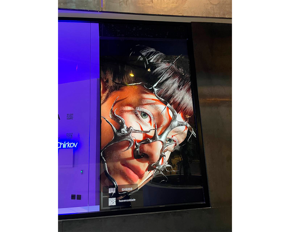 Работа художника с лицом девушки в металлической маске на экране в рамках фестиваля Repeat