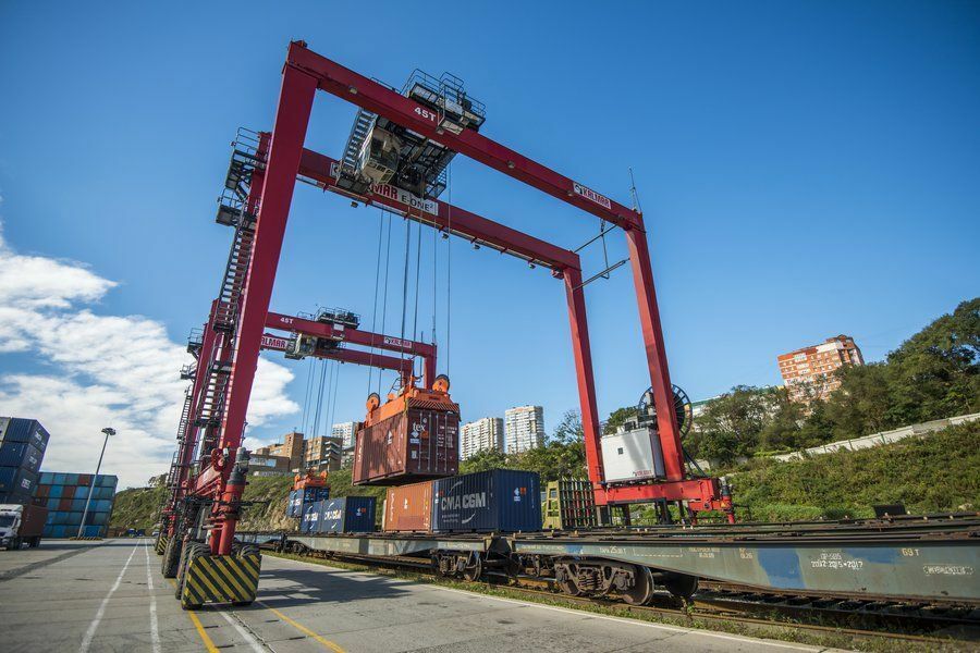 Погрузка контейнеров на железнодарожную вагон платформу в морском порту