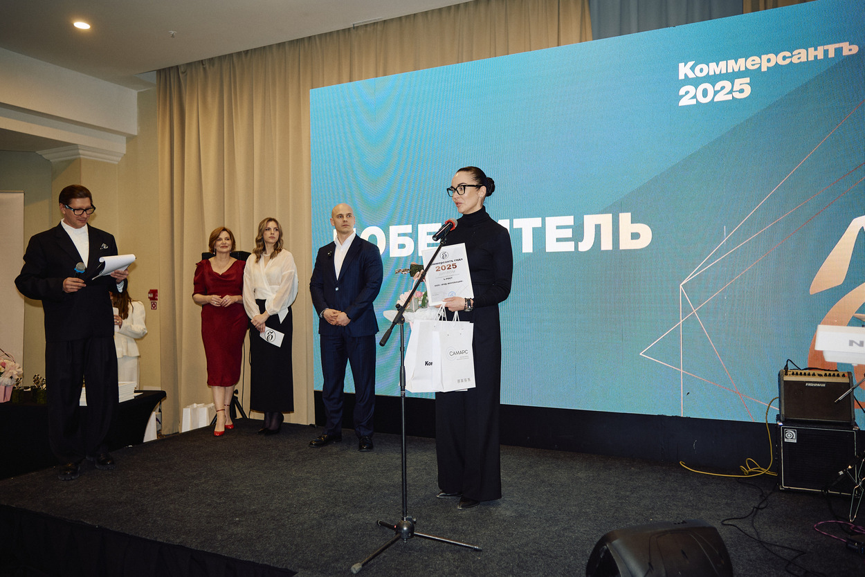 Церемония награждения премии «Коммерсантъ 2025», победитель на сцене с дипломом на фоне экрана с надписью «Победитель».